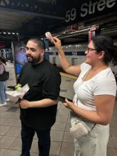 <b>Clarisa Ochoa uses a hand held fan to try to cool down her partner Salvador Gonzalez while waiting for the A train on July 18. They were visting from Los Angeles. The heat caused massive subway delays all across the city for the second day in a row. </b>Photo: Keith J. Kelly