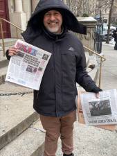 News vendor Sadik Topia in a photo last year with the front-page story in <i>The Spirit </i>detailing his plight. At the time, the city had shut him out of the newsstand he had operated for 23 years and he was temporarily selling his papers from the steps of a church across the street.