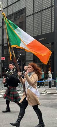 Flagbearer waves to crowd at 264th St. Patrick’s Day Parade.