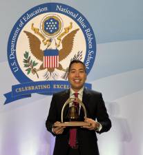 Dr. Nico Victorino, principal of P.S. 150, poses with his Bell Award at the ceremony in 2024.