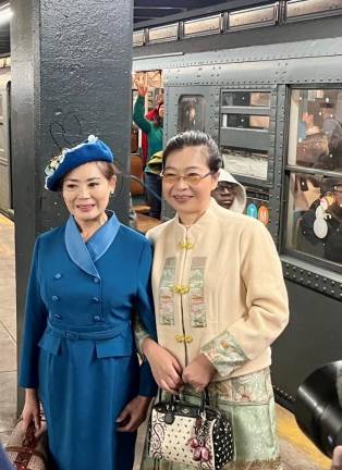 With the backdrop of the Nostalgia Holiday Train, two ladies pose as they get ready for a time-traveling ride at 2nd Avenue and Houston. Lunch? Tea? A trip half-way around the world? Or just a chance to enjoy the comforts from a 1930s subway train.