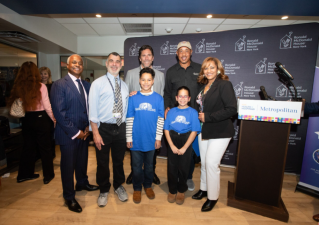 Rangers legend Henrik Lundquist (rear row left) and Knicks star John Starks (rear row right) gather with staff and patients at Metropolitan Hospital to dedicate two new rooms available to families with kids undergoing cancer treatments.