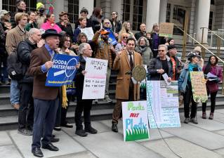 Council member Christopher Marte, front row center, leads supporters in a chant against artificial turf in New York City parks. Marte has introduced a bill that seeks to end the further usage of synthetic turf, referred to as the “Touch Grass” bill.