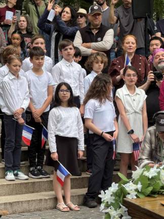 <b>Members of the PS 84 Student Choir wave French flags and perform at the rededication ceremony on May 18.</b>