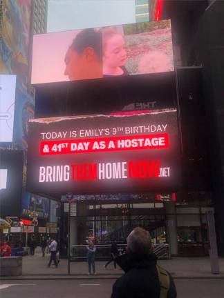 Grief stricken father, Thomas Hand, gaves up at a billboard featuring his daughter at play before she was seized by Hama in the Oct. 7 terrorist attack. His daughter turned nine years old on Nov. 17. Photo: Keith J. Kelly