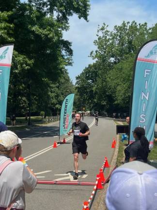 A competitive runner finishing the Juneteenth 5K, at the Seneca Village site near W. 85th St. in Central Park.