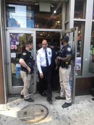 NYC Sheriff Anthony Miranda walking out of an unlicensed marijuana dispensary in May 2024, after a local operation to shut down such stores began. The local program is tied up in court after reportedly closing 1,300 smoke shops, while a state initiative that has closed only 59 shops in Manhattan last year is ongoing.