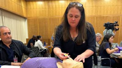 Kristen Harty, a substance abuse prevention and intervention specialist, practices administering Naloxone during a June 24, 2024 training at NYU Langone Hospital. (Michael Elsen-Rooney / Chalkbeat)