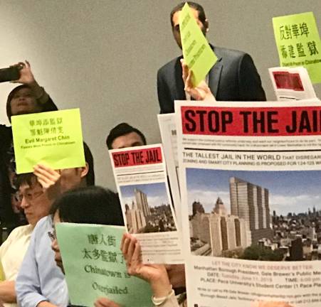 Signs at the sometimes-raucous June 11 forum that Manhattan Borough President Gale Brewer hosted at Pace University. Photo: Stuart Marques