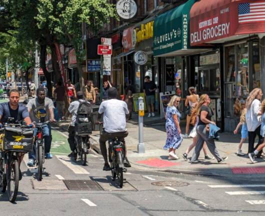 E-bikes at 9th Avenue and 45th Street, Hell’s Kitchen, August 2024. E-bikers occasionally head in the wrong direction (note “WRONG WAY” sign), leading some city council members to call for new regulations