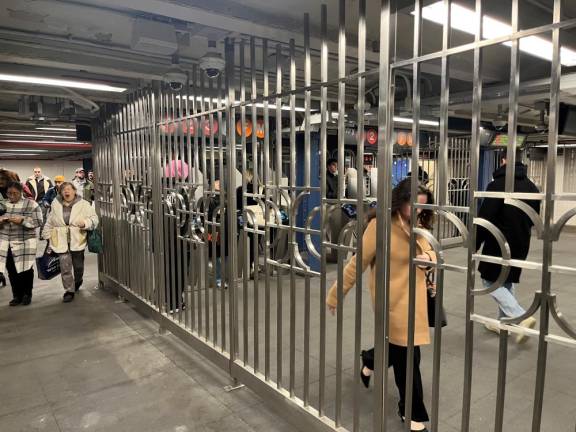 The new mezzanine complex at 14th Street and 7th Avenue offers a break from the dark vertical and horizontal bars that separate those entering and leaving the subway station. Here, a silver hue offers a change from the commonplace.