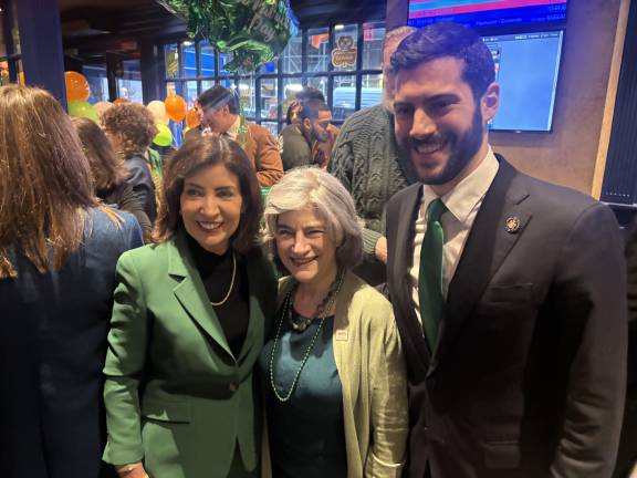 Governor Kathy Hochul (left) whose grandparents were from County Kerry, drops by the Lexington Democratic Club pre-parade at Stout on E. 41st St. and meet Lori Bores (center) mom of NY State Assembly member Alex Bores (right).