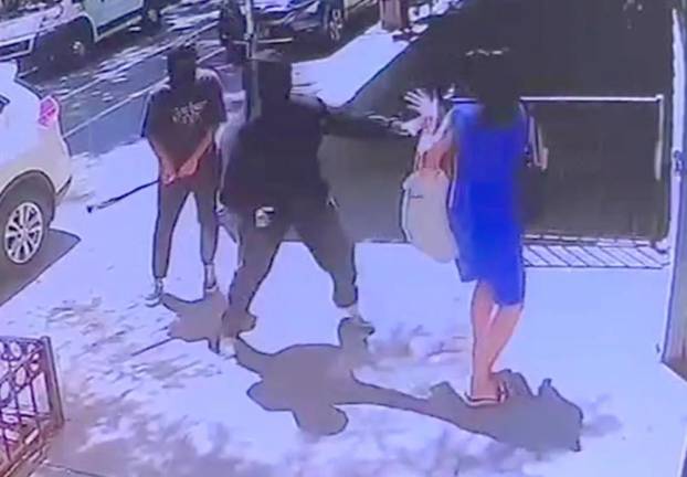 Shi Yahan, in blue dress, moments before she was brutally beaten by two masked thugs outside 37 Monroe Street, Tuesday June 25, at approximately 1:58 p.m.