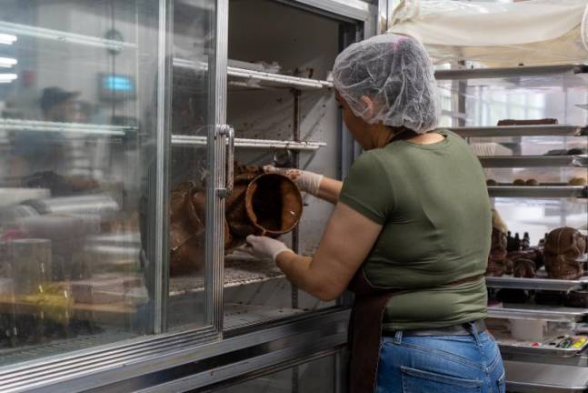 Damarys places a finished mold into the fridge to quicken the cooling process.