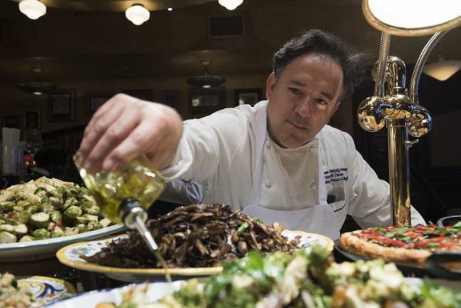 Chef Brando de Oliveira applies some olive oil at Bond 45 restaurant.