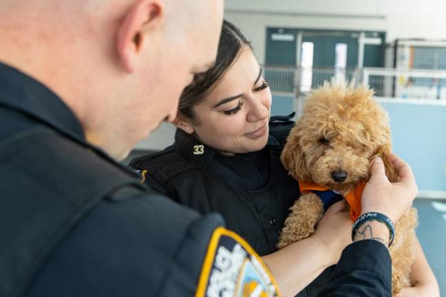 Officer Garcia holds Rocket, the dog whose life she saved back in May.