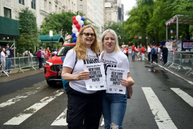 Daily News workers holding mock front page flyer: Defend The Daily News! New York Needs Its Hometown Paper. The paper’s journalists, re-joined the journalist’s union after the embattled tabloid was taken over by a hedge fund which drastically slashed the staff.