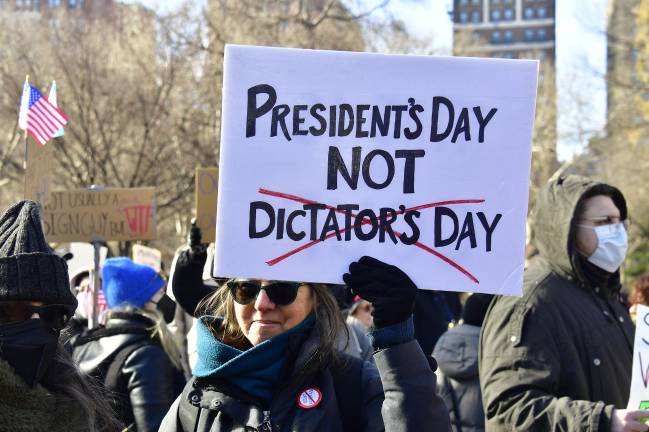 A protestor in Washington Square Park with a sign reading, “President’s Day Not Dictator’s Day.”