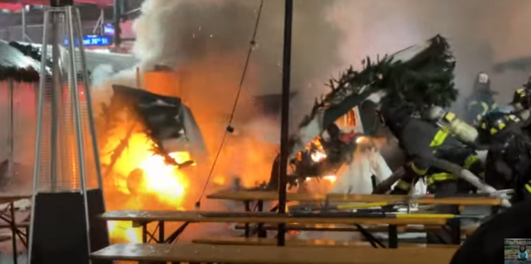 Another angle of a stall during down at the Herald Square Holiday Market on the morning of Dec. 16, with firefighters (right) battling the blaze.