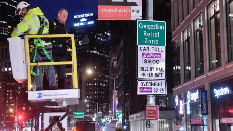 MTA chairman Janno Leiber unveils a congestion pricing sign at midnight on Sunday, Jan. 5 on the first day of the toll.