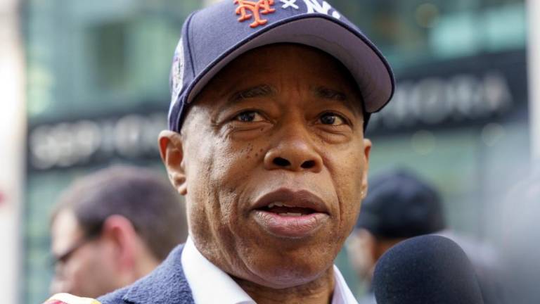 A Mayor for All Post-Seasons: Paying tribute to both of the city’s playoff teams, Eric Adams wore a startling dual-logo Mets / Yankees baseball cap at the Columbus Day Parade, October 14, 2024.