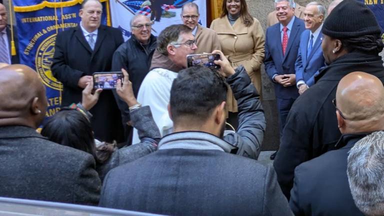 The blessing of the Workers Chapel on W. 31st St: Father Brian Jordan in white and brown frock. Behind and to the right of his head stand BP Mark Levine, AG Letitia James, Brooklyn DA Eric Gonzalez and State Comptroller Thomas DiNapoli.